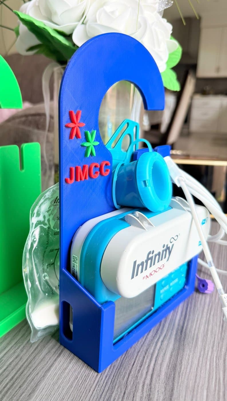 The holder seen from the side: the feeding pump sits in the base with the feeding bag cradled directly above it, and the tubing runs off to one side.